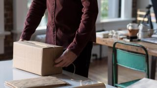 A person lifting a packing box.