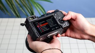 The Sony A7CR on a white table with a blue wall in the background