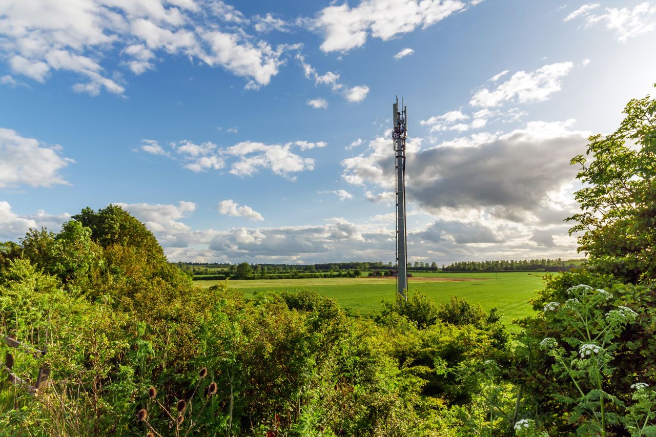 Sunset view of a British Mobile Operator Mast over field.