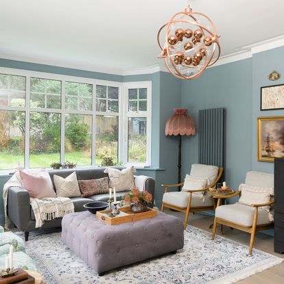 blue living room with grey sofa and armchairs