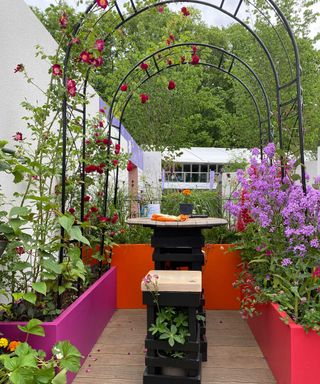 metal arches with climbing roses on decking balcony at chelsea flower show 2022