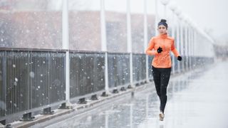 Woman on bridge running in rain