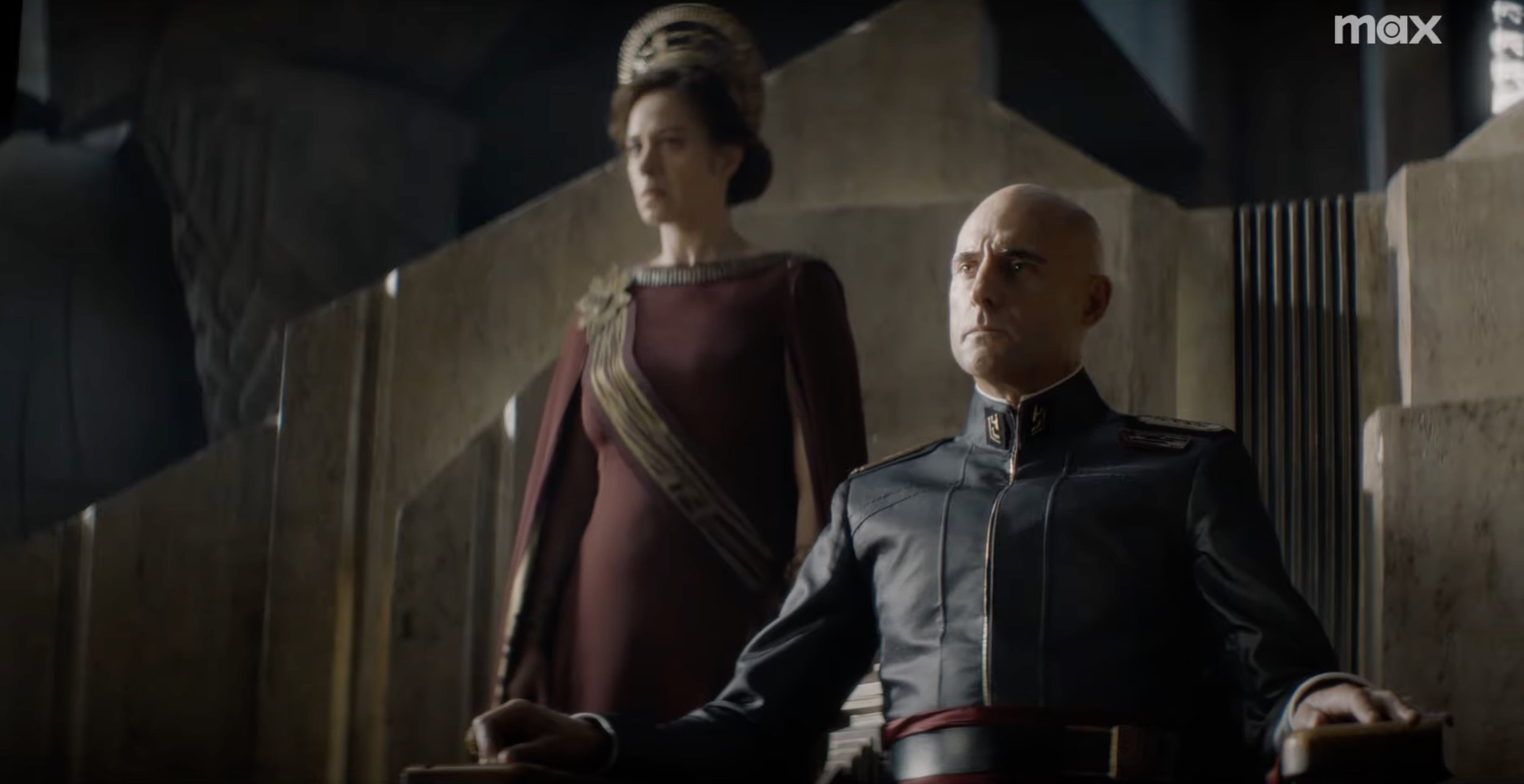 A royal sci-fi figure sits on a throne next to his queen