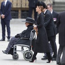 India Hicks walking behind Lady Pamela Hicks in a wheelchair at Queen Elizabeth's funeral