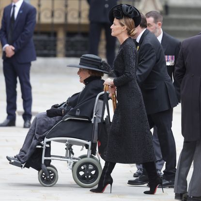 India Hicks walking behind Lady Pamela Hicks in a wheelchair at Queen Elizabeth's funeral