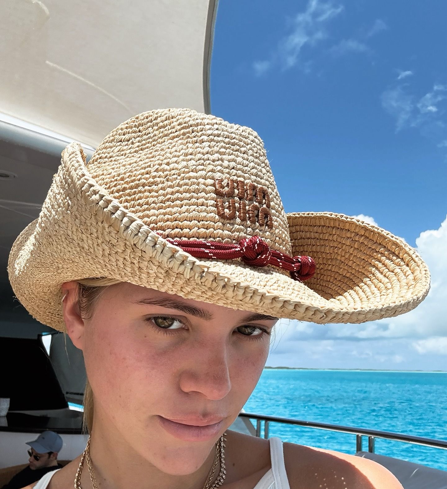 Sofia Richie wearing a raffia cowboy hat with a swimsuit