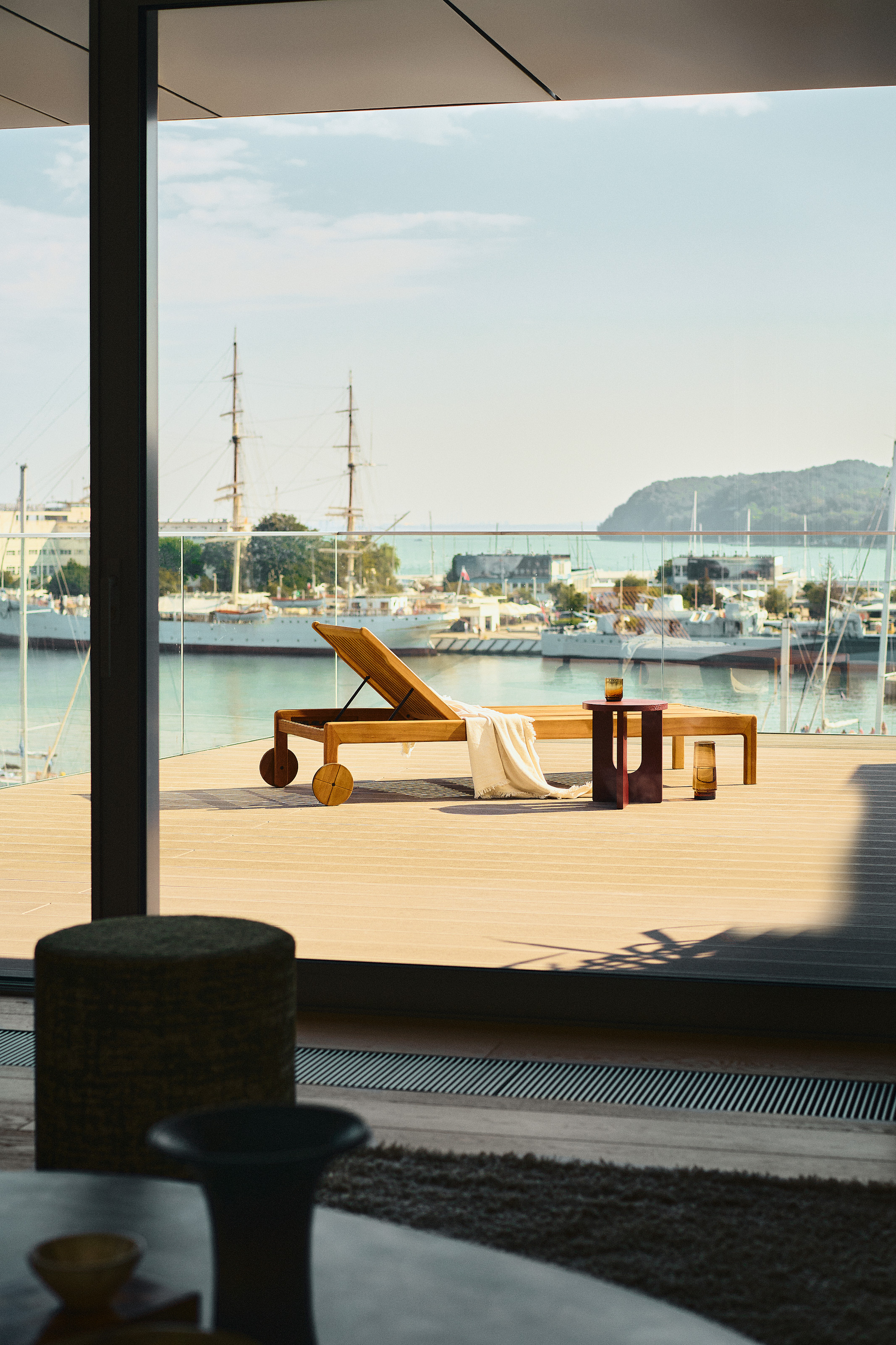 A sunbed on a deck leading out from the house though sliding doors