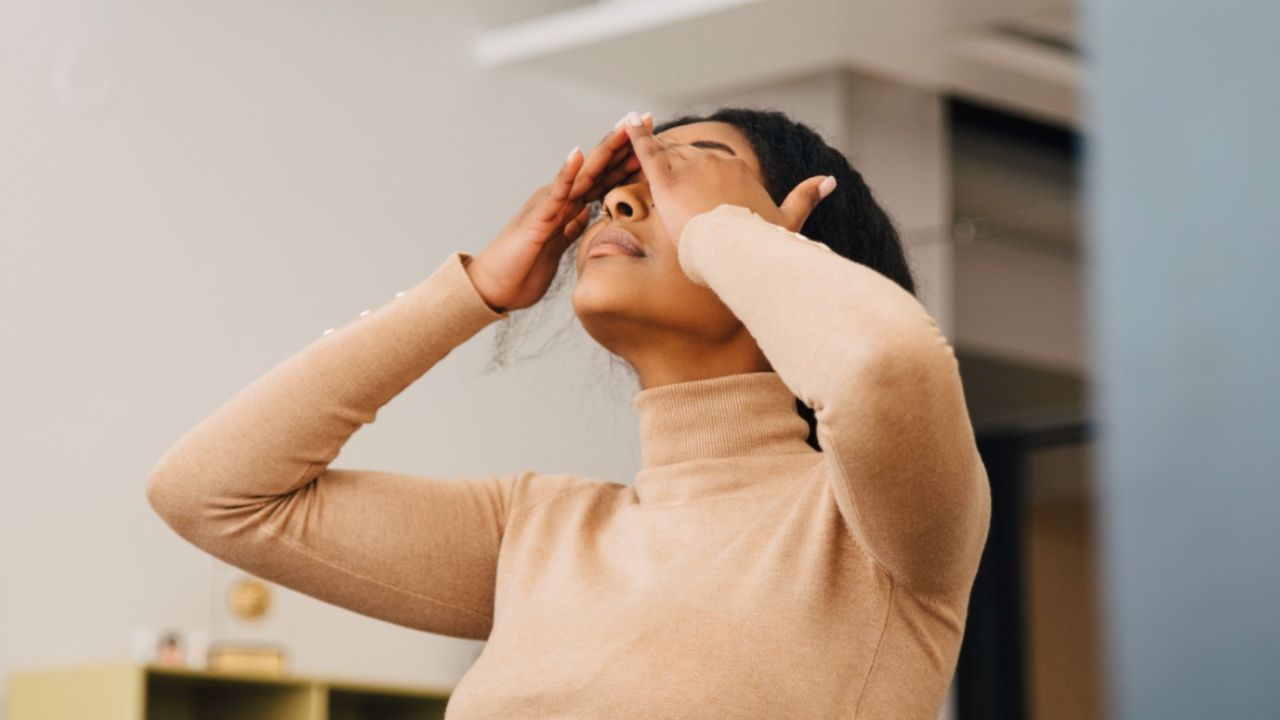 Woman holding her head, feeling burnt out during work