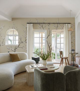 living room with white curved sofa and floral wallpaper