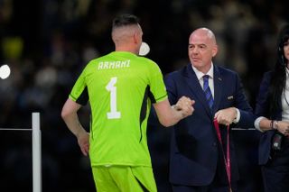 Argentina goalkeeper Franco Armani collects his World Cup winners' medal from FIFA president Gianni Infantino after victory over France in the final of Qatar 2022.