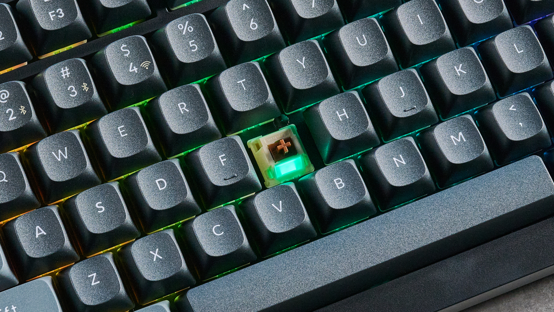 Keychron V3 Ultra 8K photographed on a grey table top in front of a blue background