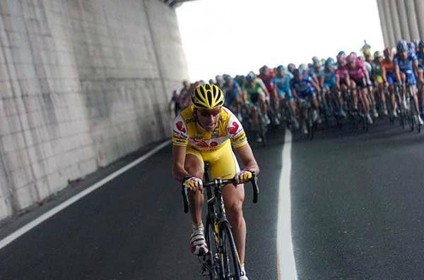 Andrea Tafi in no-man's-land with the peloton breathing down his neck.