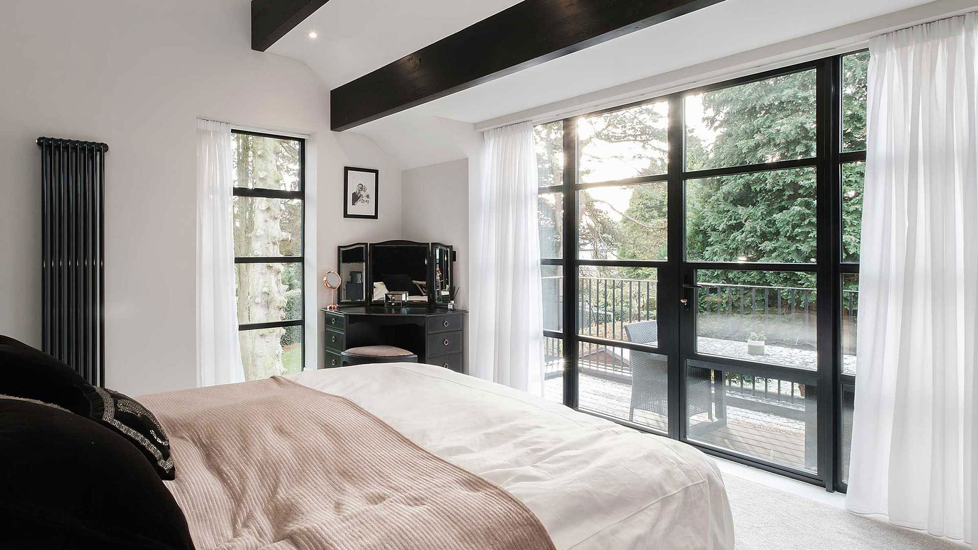bedroom with heritage Crittall-style French doors to balcony