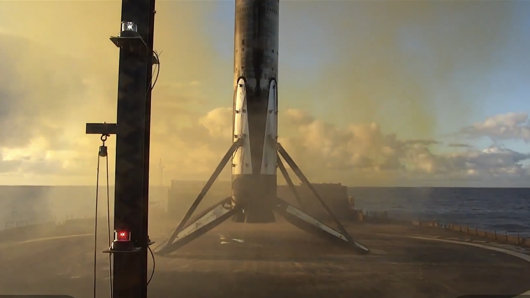 a landed booster stage on a barge at sea.