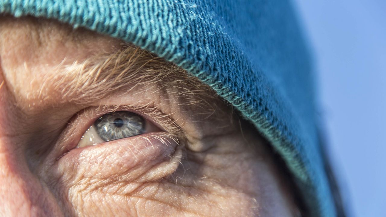 A closeup of a man&amp;#039;s weathered face looking warily into the distance.