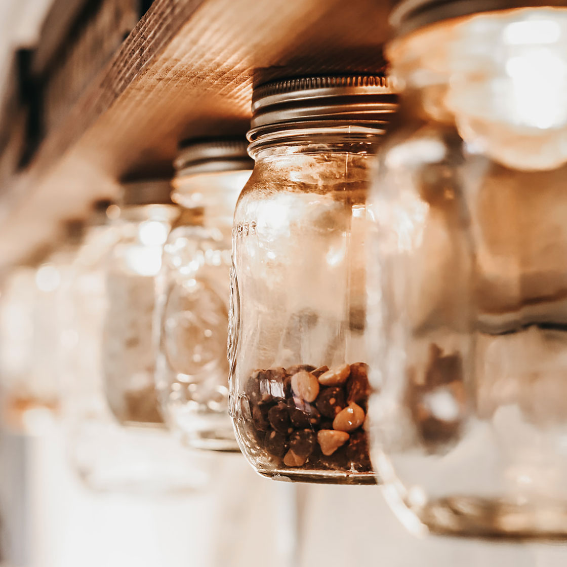 Mason jars hanging from the side of kitchen space in converted bus