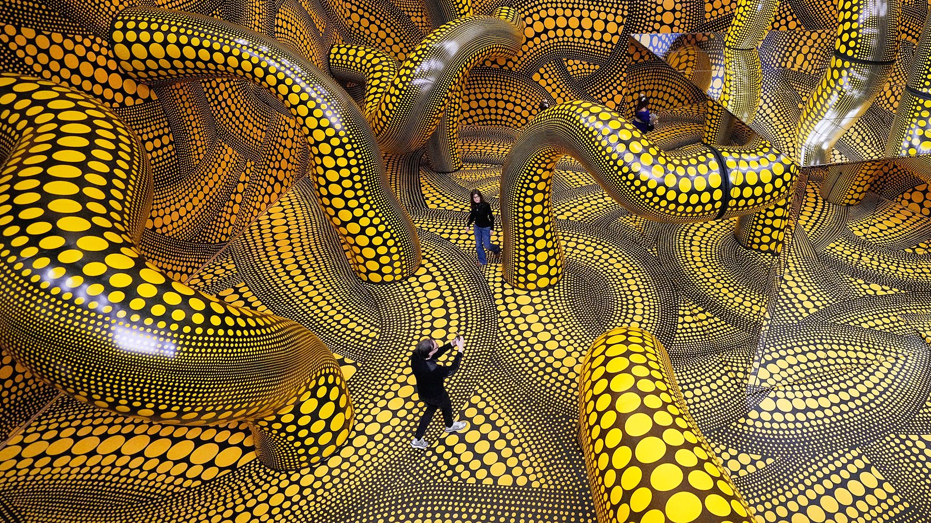 
                                People walk through Yayoi Kusama's 'Infinity Mirrored Room' art installation at the Museum Ludwig in Cologne, Germany
                            