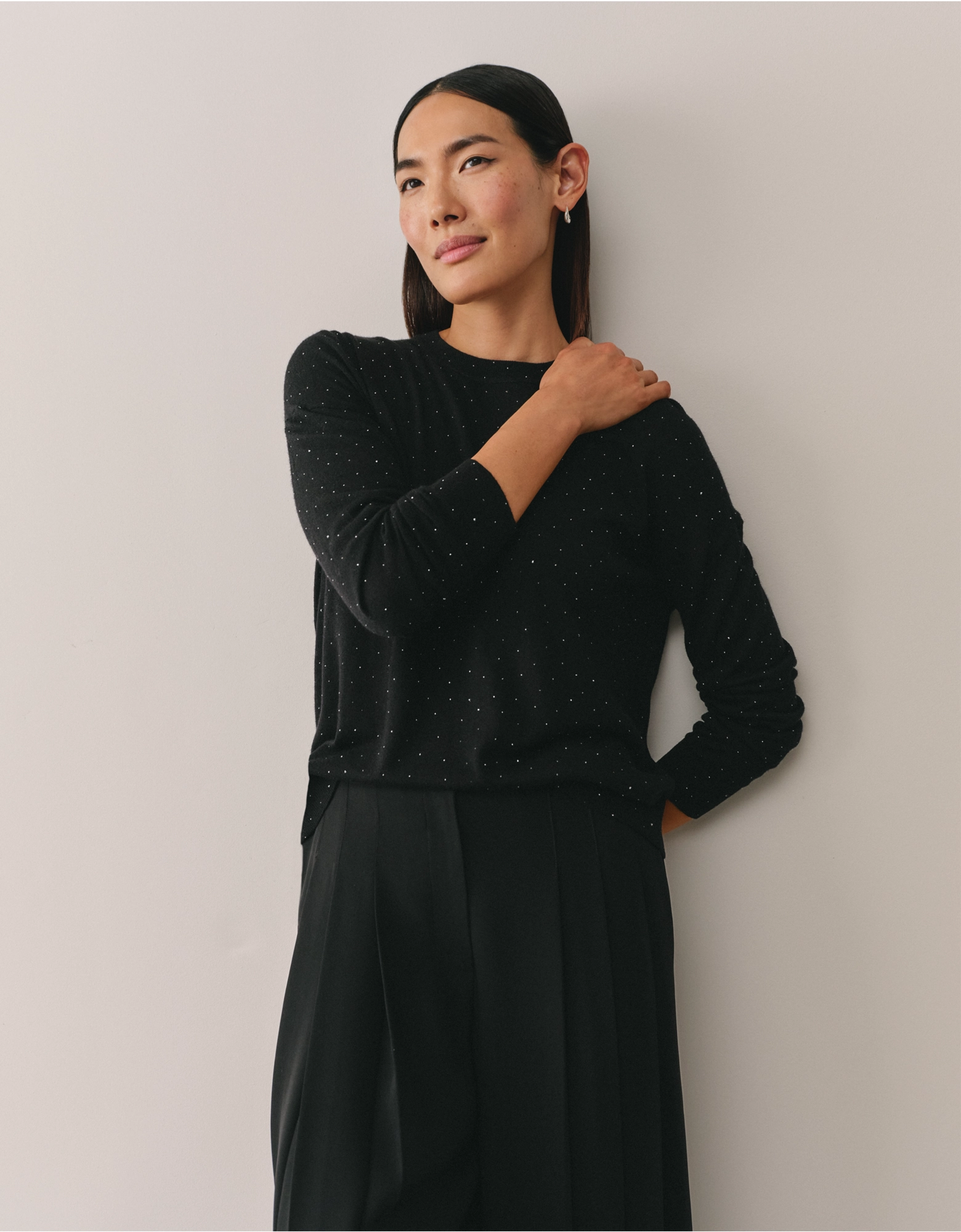 a model wearing a black embroidered jumper from the white company