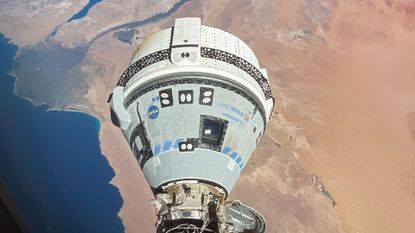 A photo showing the Boeing Starliner in orbit above the Earth