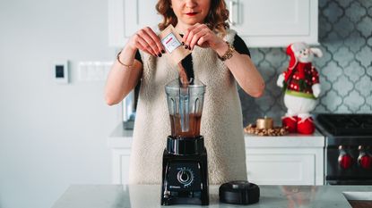 A woman prepares a healthy smoothie with one of the best blenders