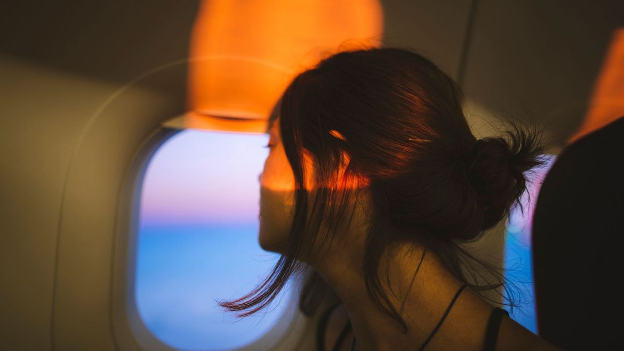 Woman looking out of airplane window