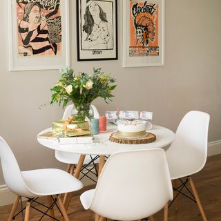 white wall with flower vase and white table with chairs