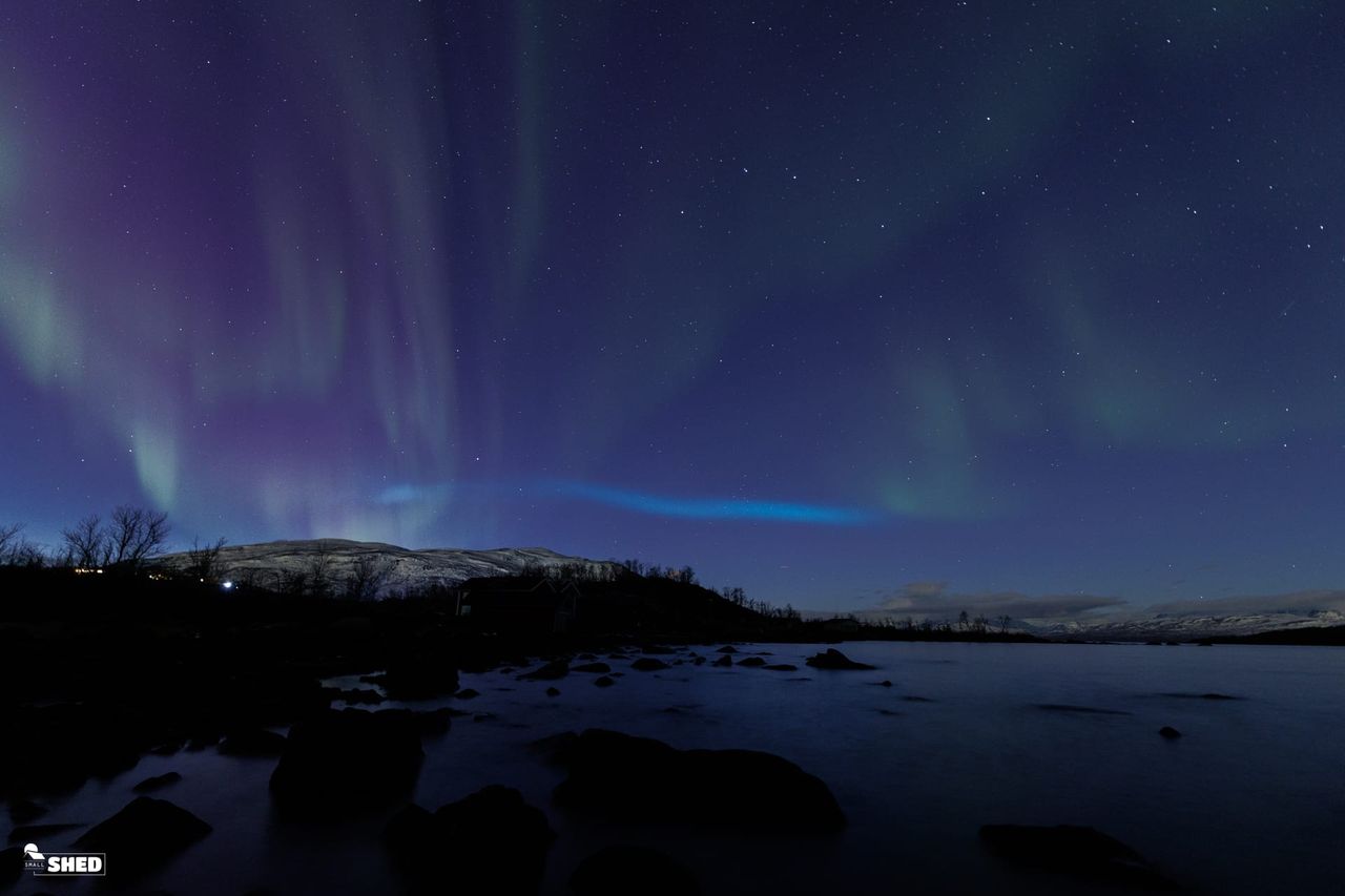 blue ribbon of light appearing over Abisko National Park, Sweden.