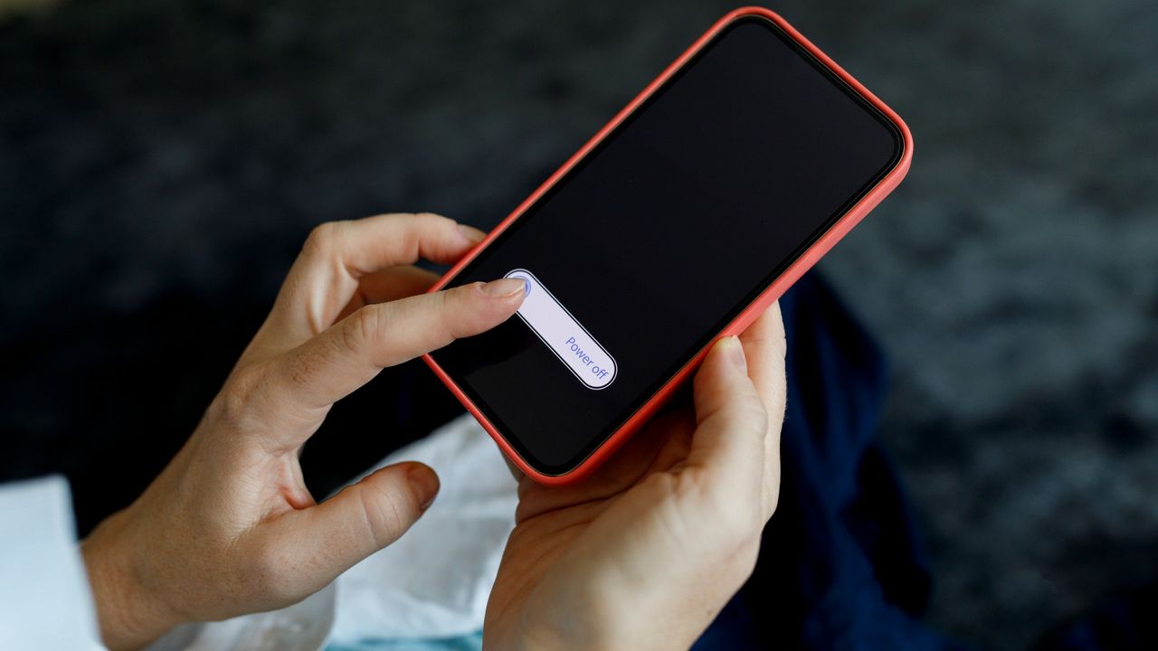 Woman&#039;s hands turning off mobile phone 