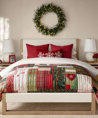 Bedroom decorated for christmas with patchwork quilt and wreath above the bed