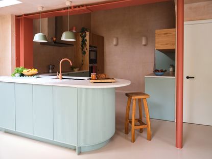 soft blue curved kitchen island with plaster pink walls