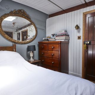 b edroom with mirror and wooden drawer