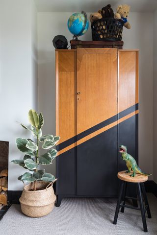 Vintage-style wardrobe with black geometric stripe and block colour in a diagonal line across the bottom half