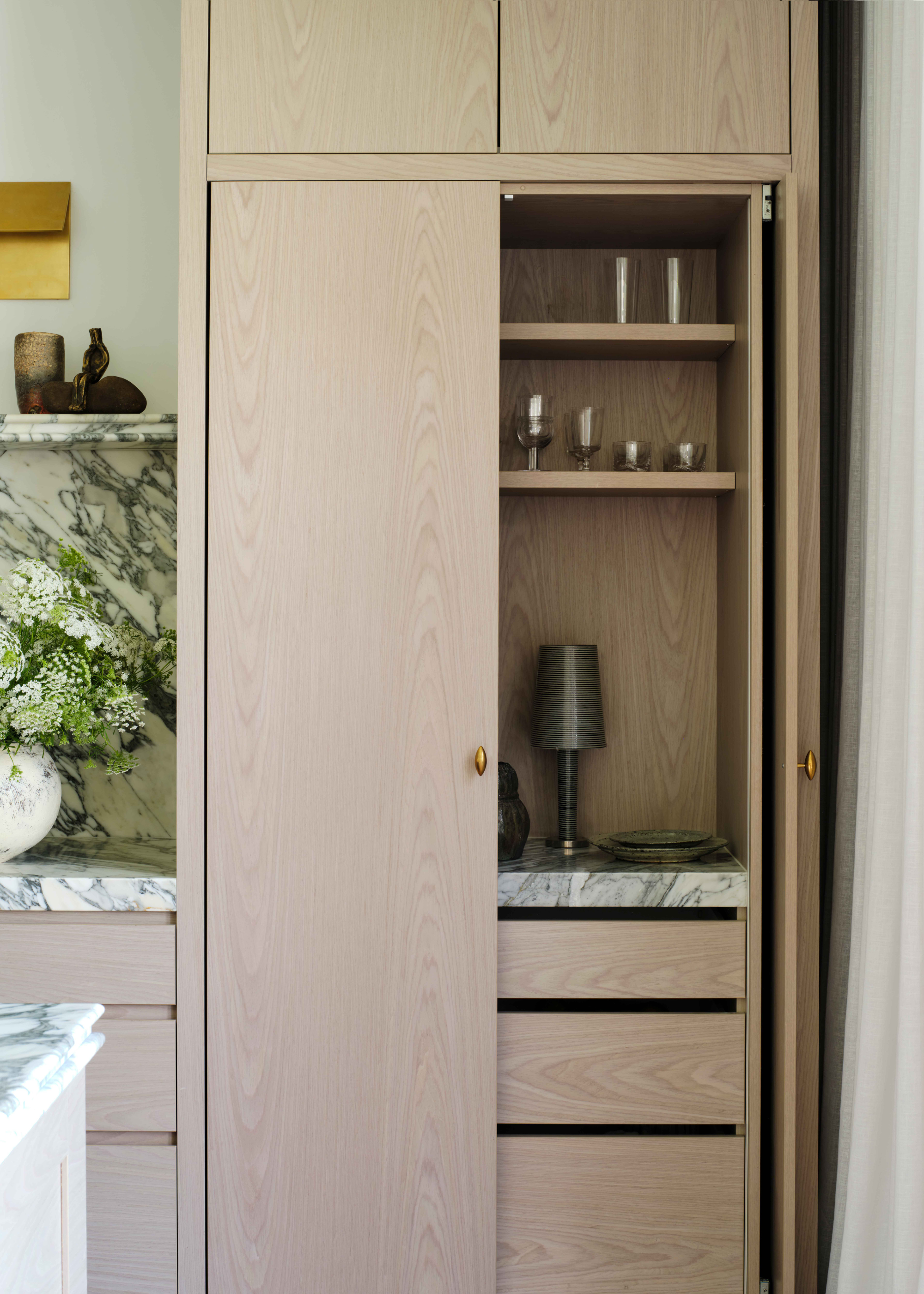 A wooden hosting cabinet with a marble counter