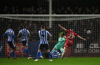 Aidan Keena of Cheltenham Town scores the team's first goal past David Stockdale of Sheffield Wednesday during the Sky Bet League One between Cheltenham Town and Sheffield Wednesday at Completely-Suzuki Stadium on March 29, 2023 in Cheltenham, England.