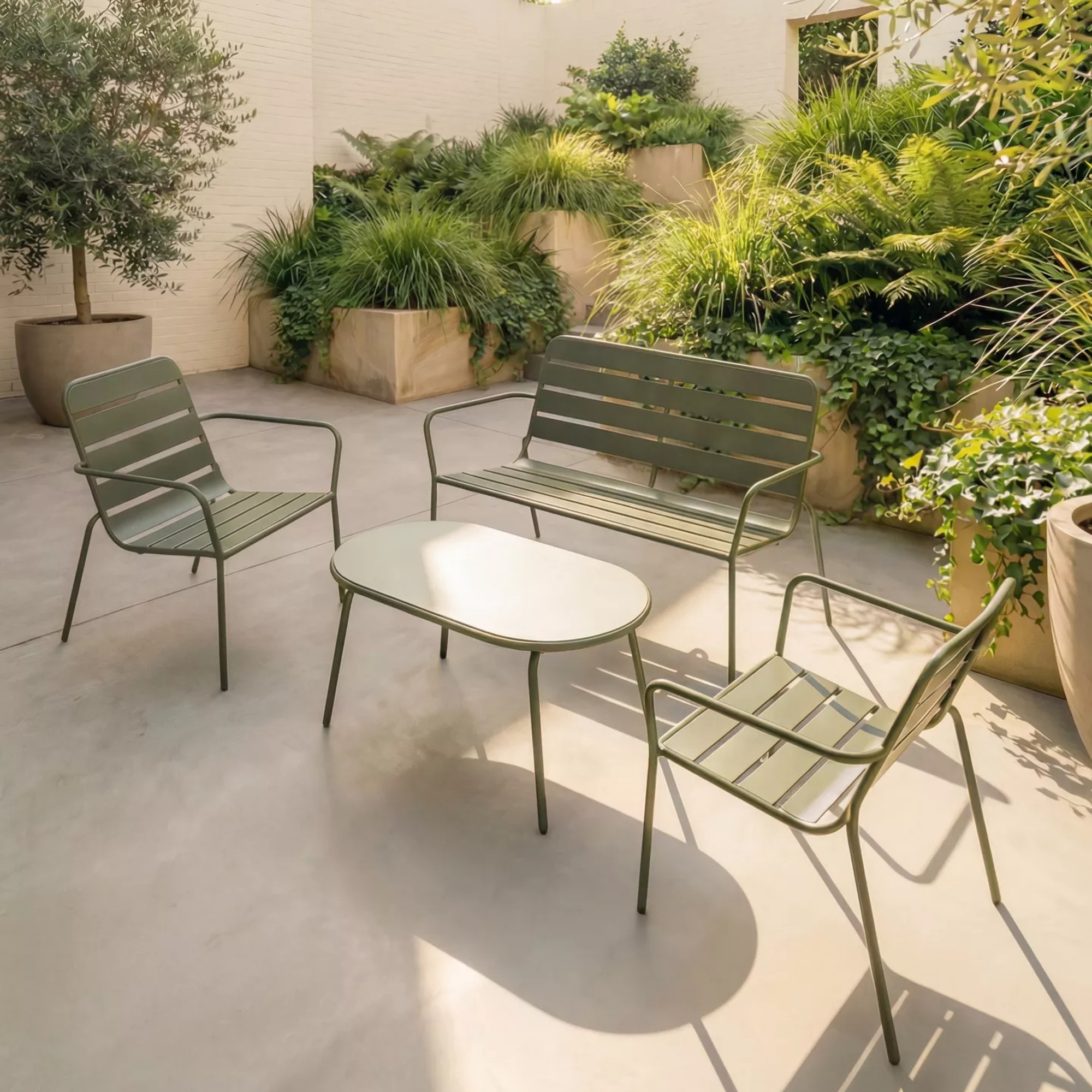 John Lewis Metal Garden Lounge Chairs with a matching table and bench in avocado green in a Mediterranean-style garden