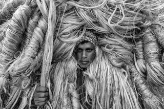 Man's face emerging from a pile of twine