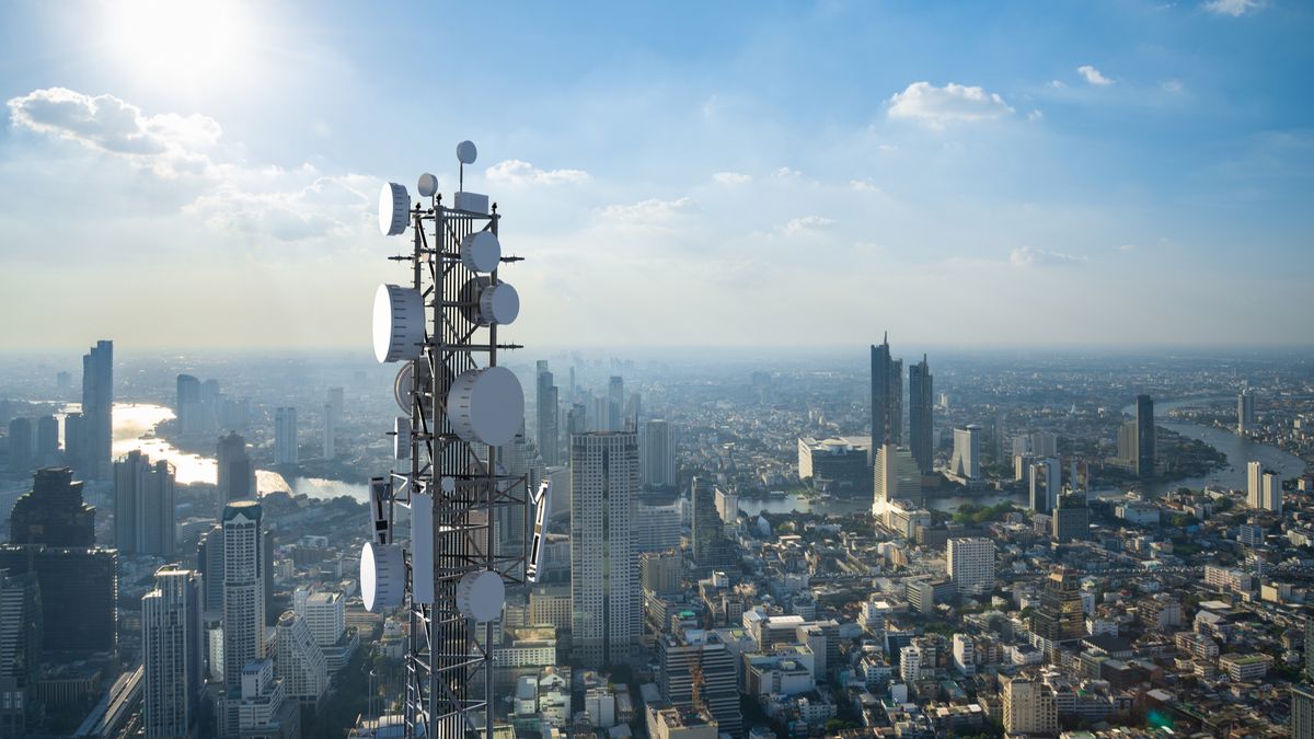 Telecommunication tower with 5G cellular network antenna on city background