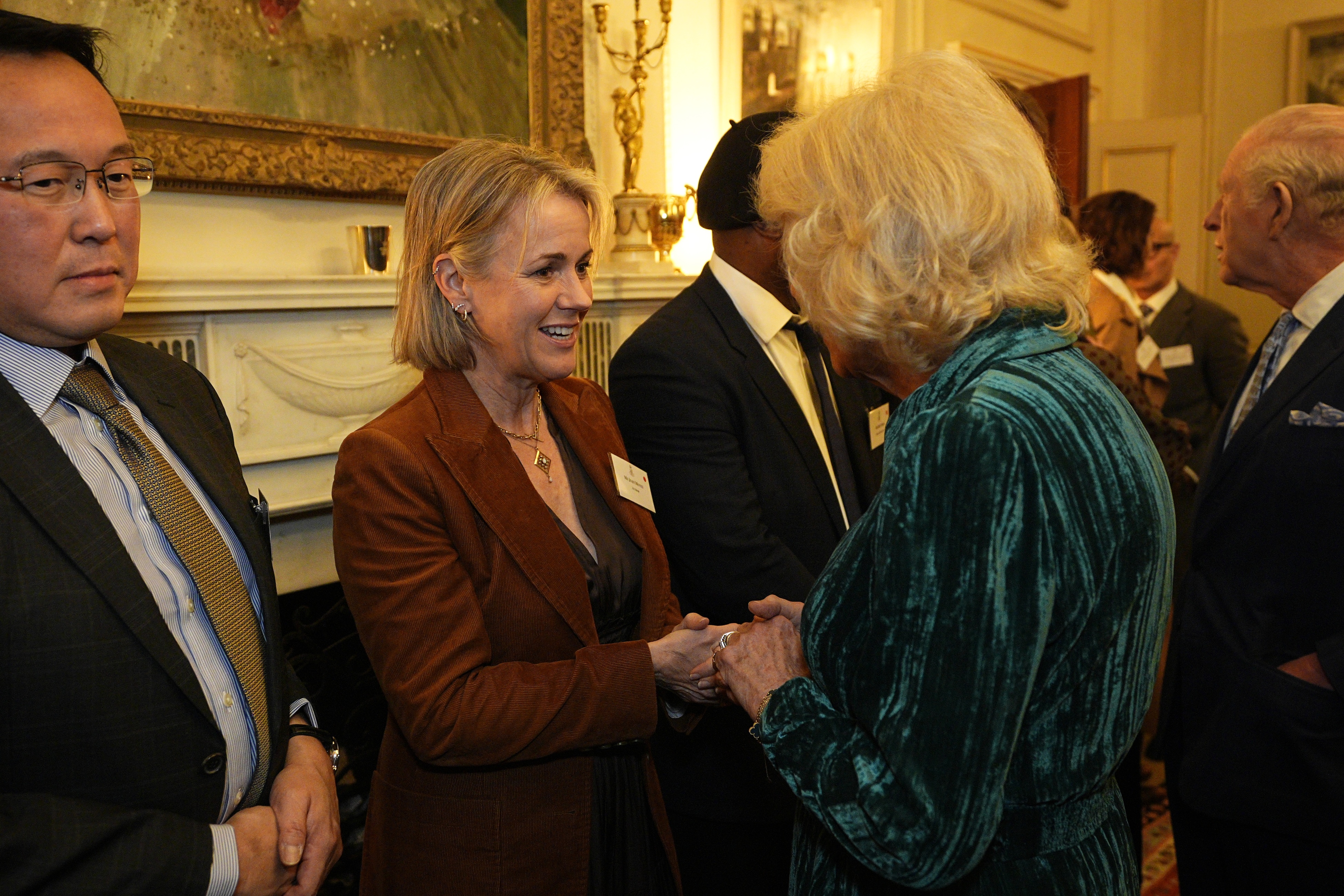 Queen Camilla holding hands with Jojo Moyes