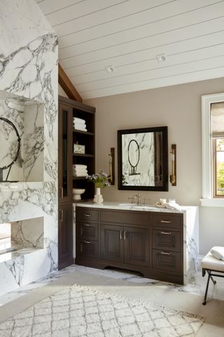 marble and dark wood bathroom with built in shelving