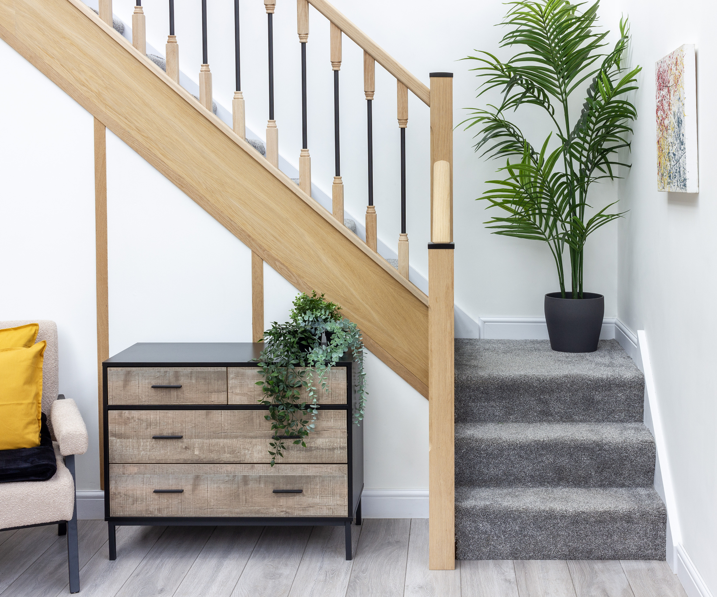 oak staircase with metal spindles carpeted in grey