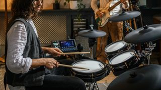 Man playing the Alesis Strata Core electronic drum set