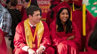 Ben and Devi sitting next to each other smiling after graduation.
