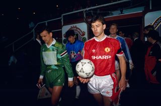 Bryan Robson leads out Manchester United for a European game in 1991.