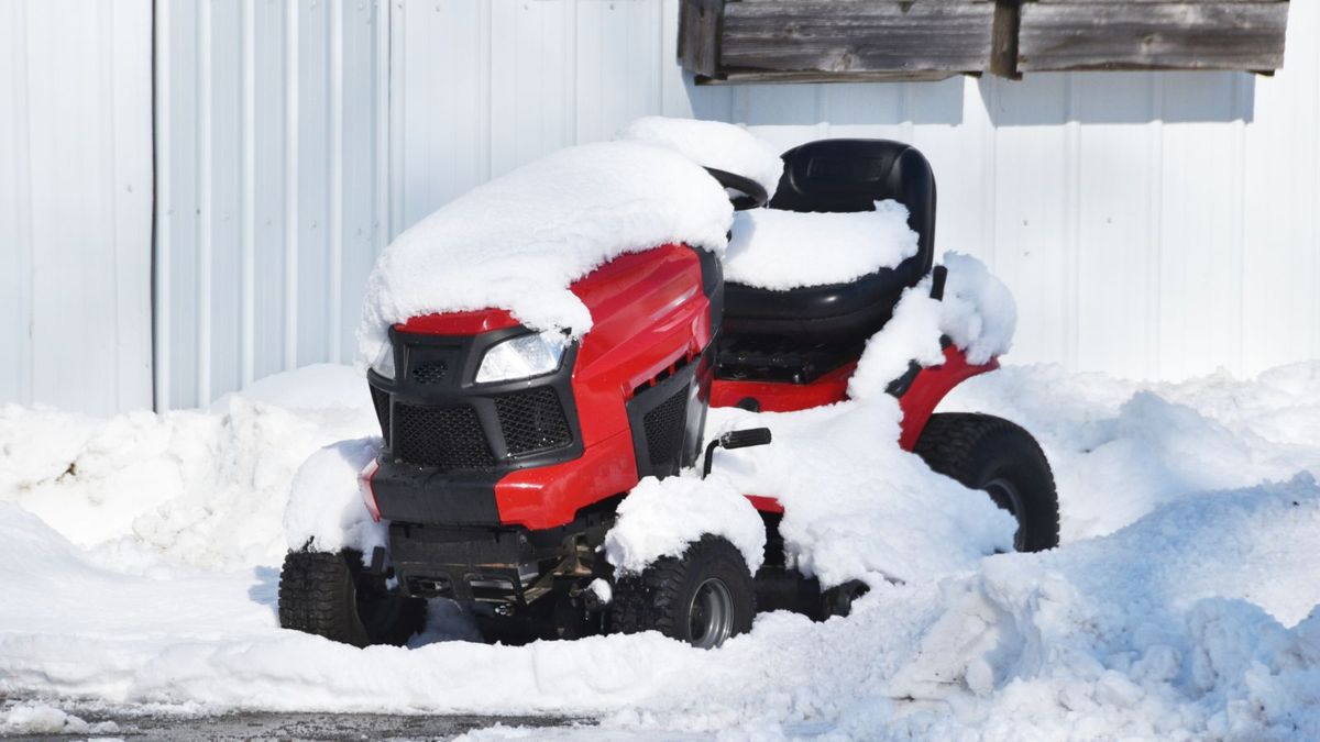 Lawn mower covered in snow - winterization service
