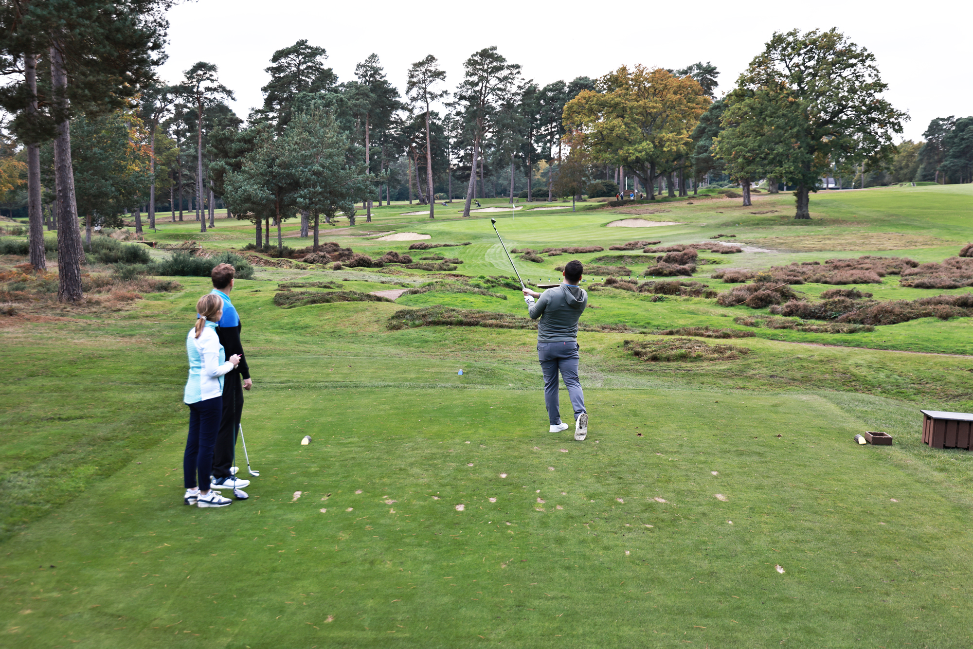 Sam De'Ath teeing off on a par-3 at West Hill Golf Club, watched by his playing partners on the tee box