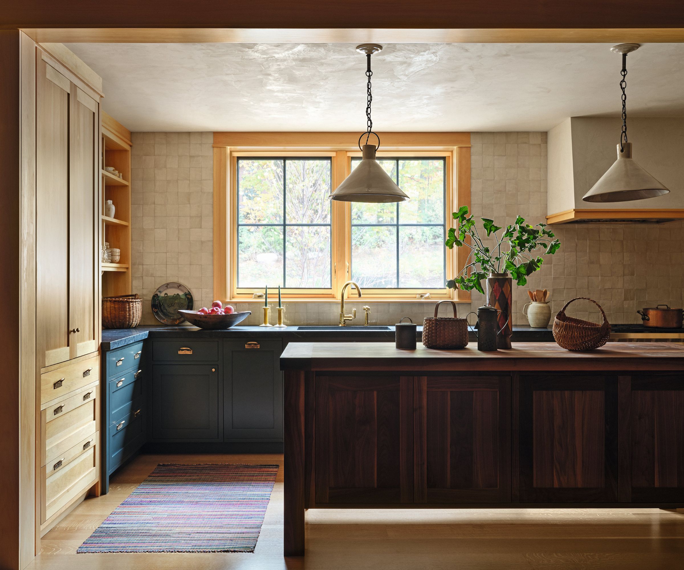 Blue and wooden kitchen with dark wooden island and yellow framed windows