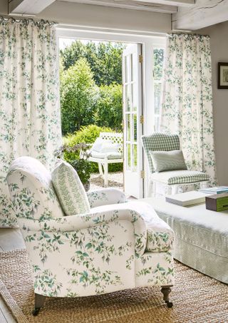 Foliage and floral trail curtains by open window with matching armchair