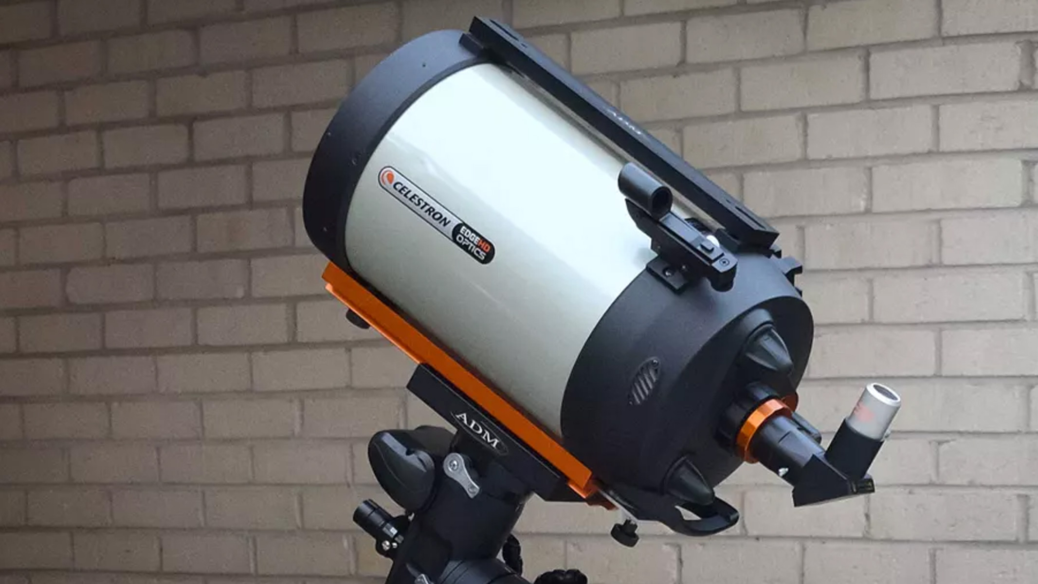 Telescopio Celestron Advanced VX8 edge HD contra una pared de ladrillos