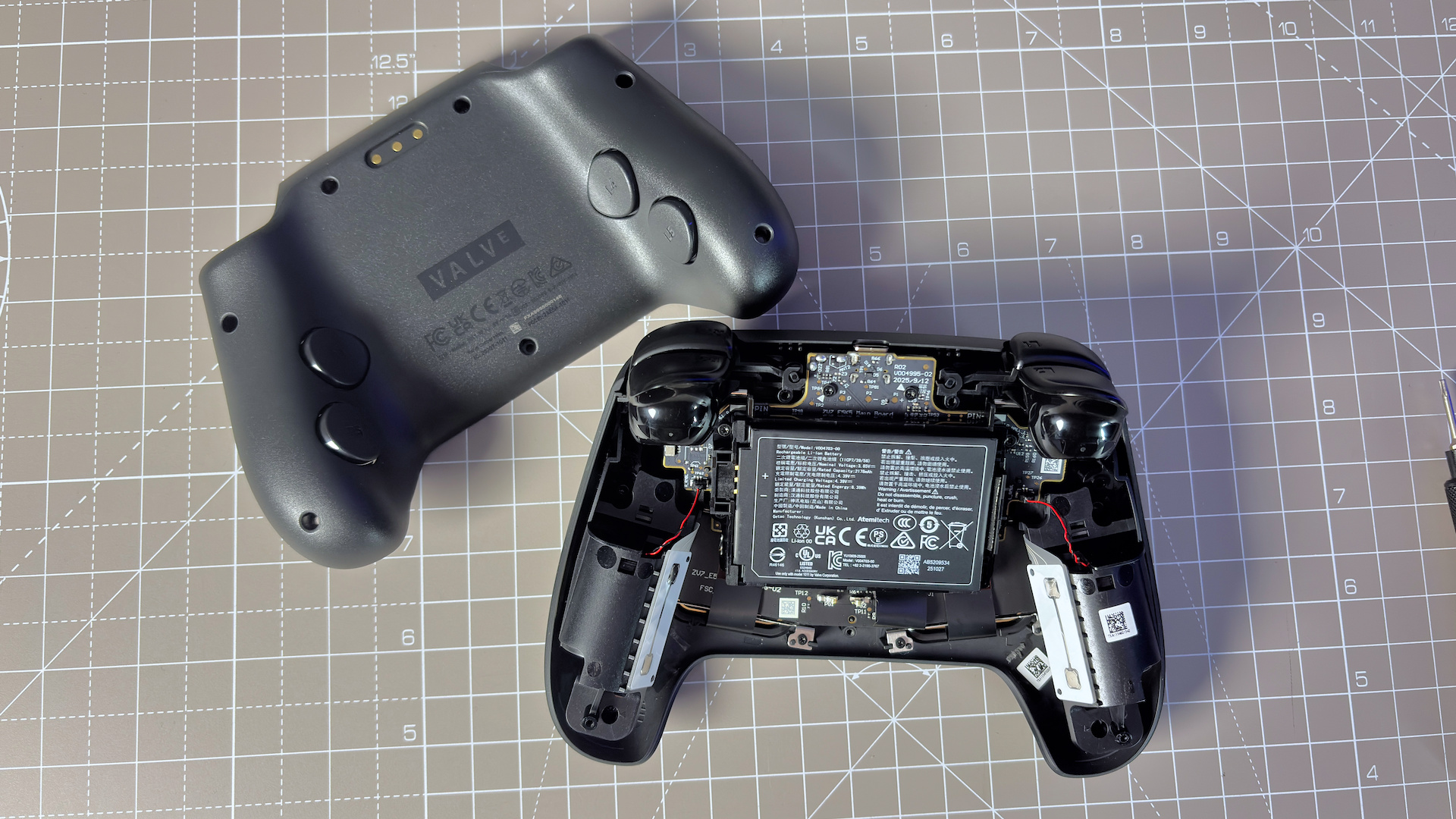 The Steam Controller on a desk during a teardown, with various parts removed.
