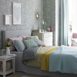 bedroom with grey designed wall frames on wall and white drawers